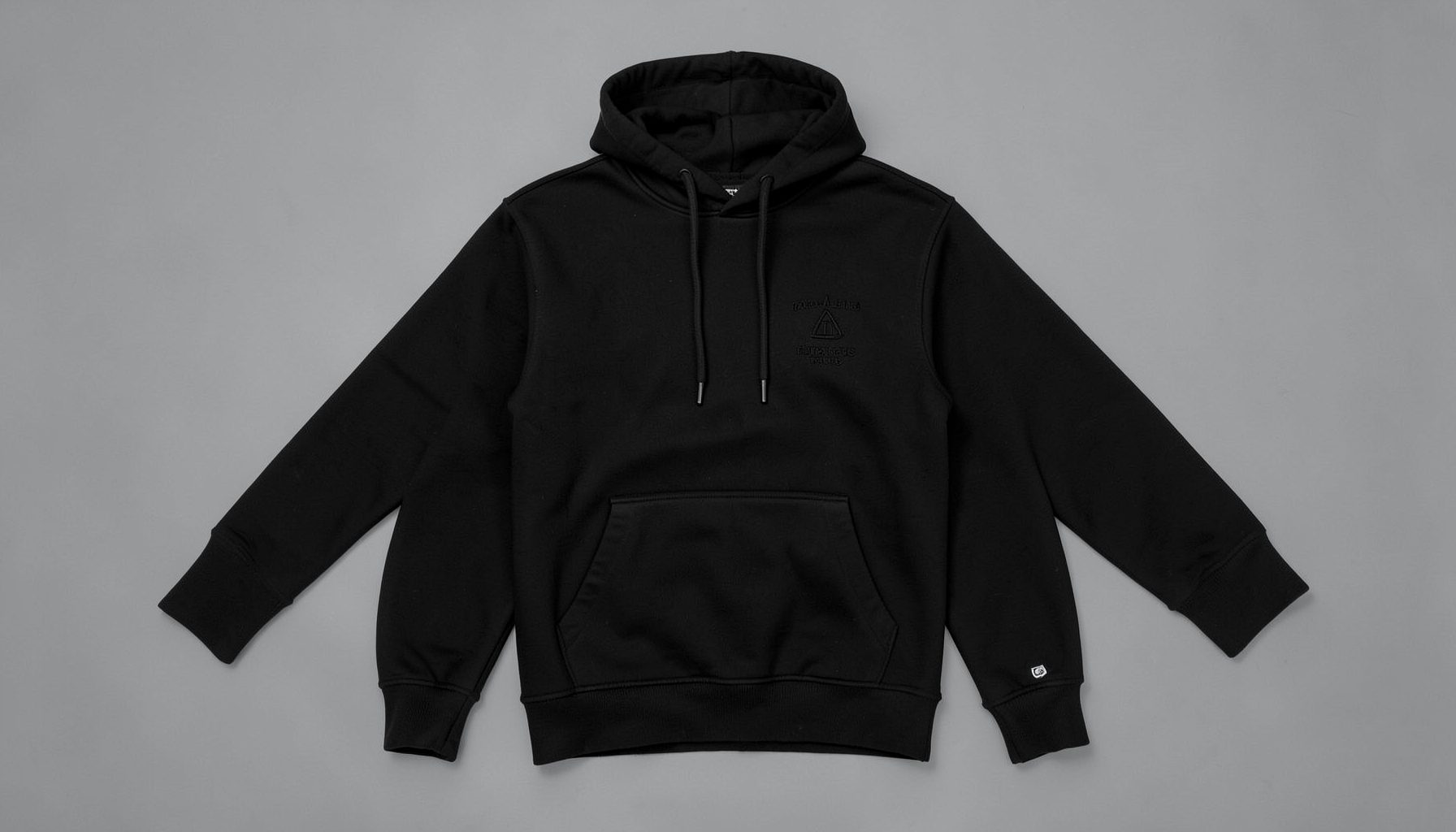 A black hoodie with subtle embroidered detailing, shown on a neutral grey background